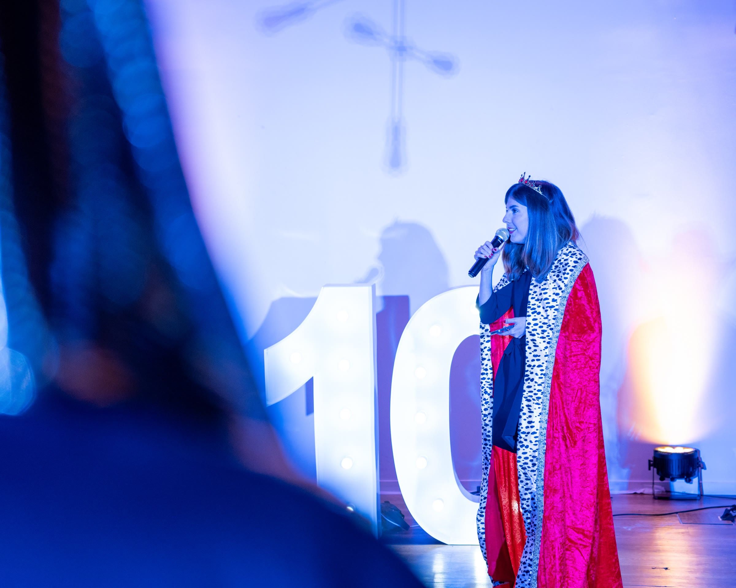 Une chanteuse sur scène devant le grand « 10 » lumineux