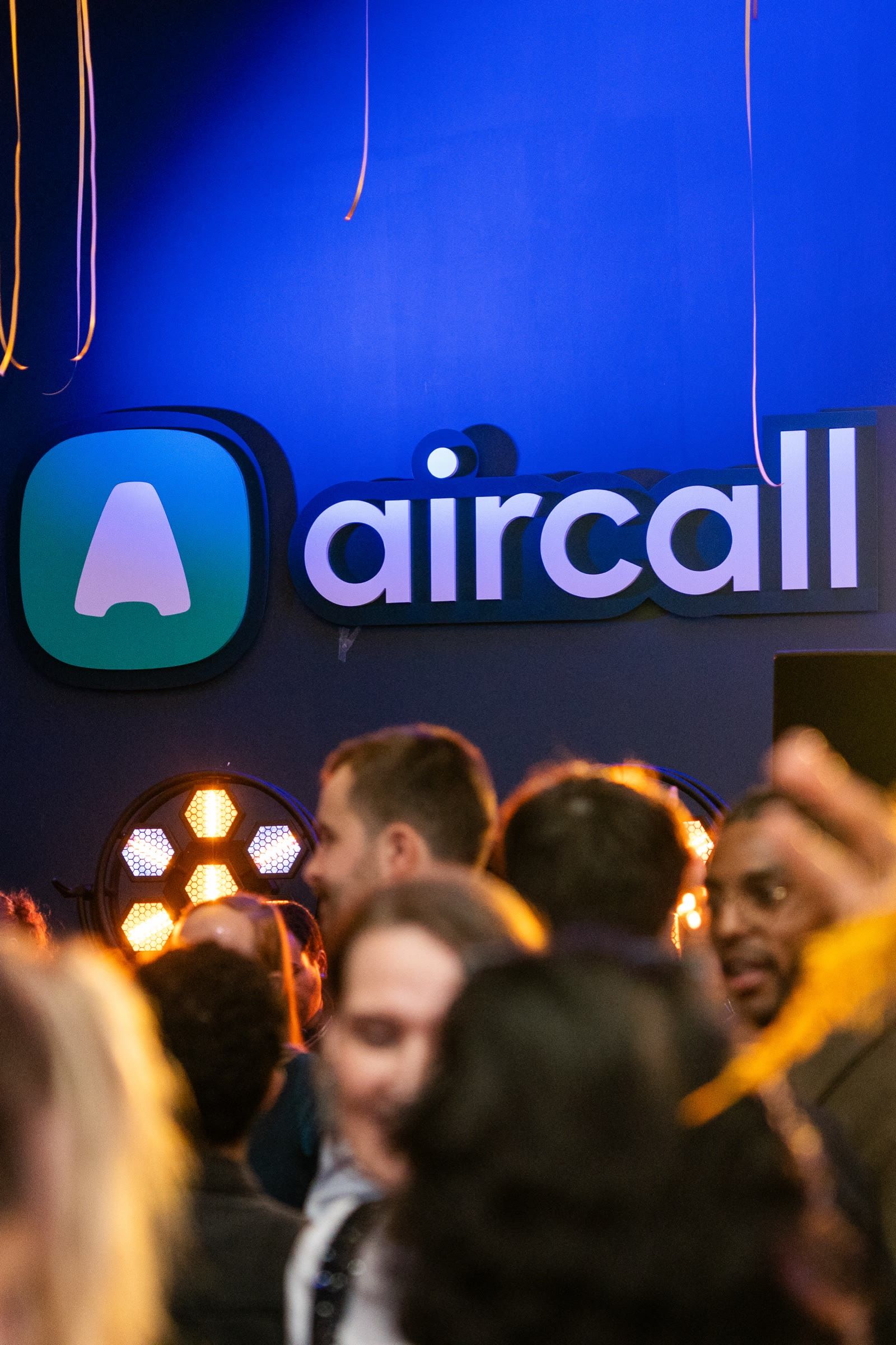 Les invités devant le logo Aircall lumineux