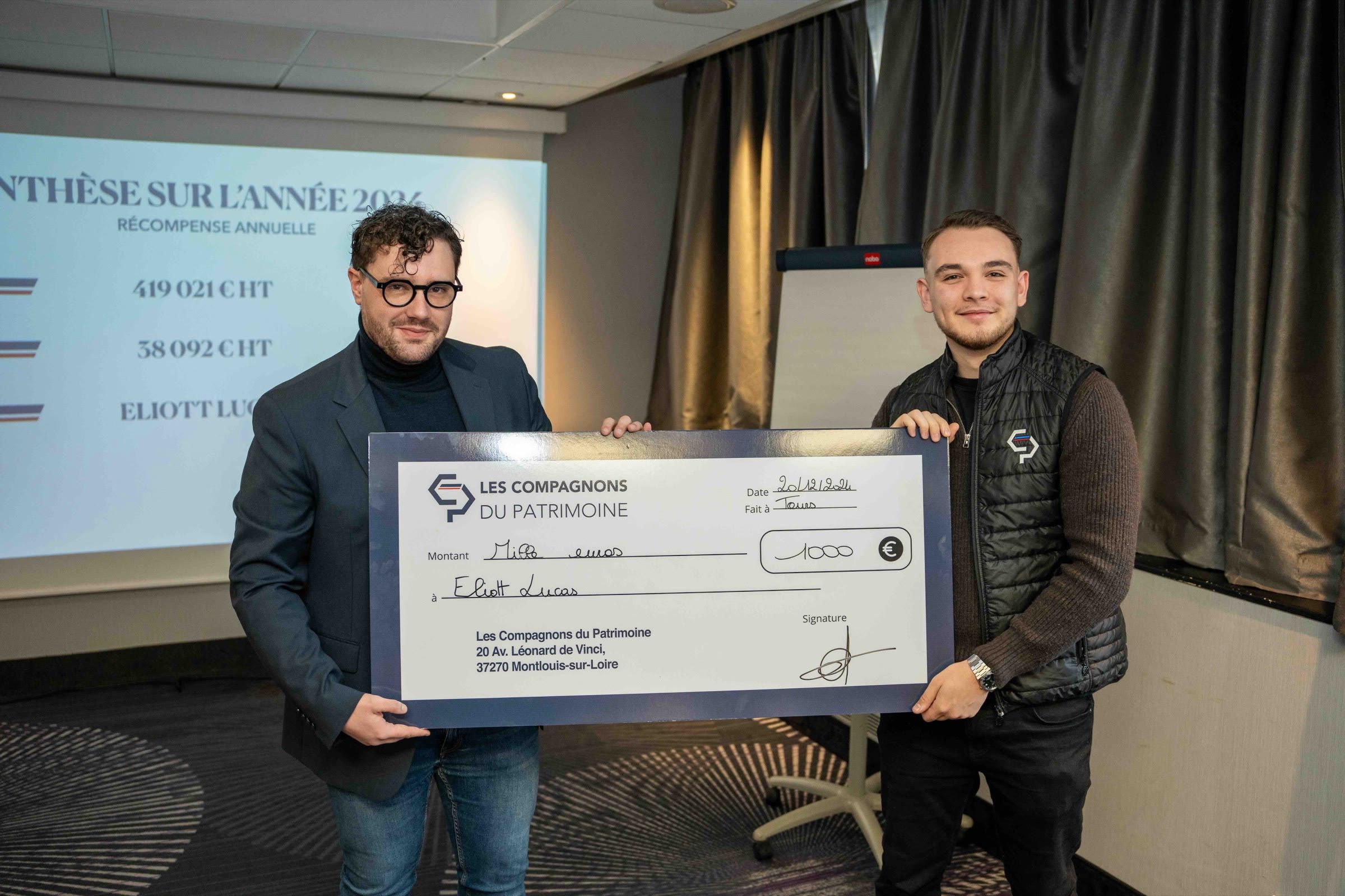 Remise d’un chèque géant devant l’écran de présentation