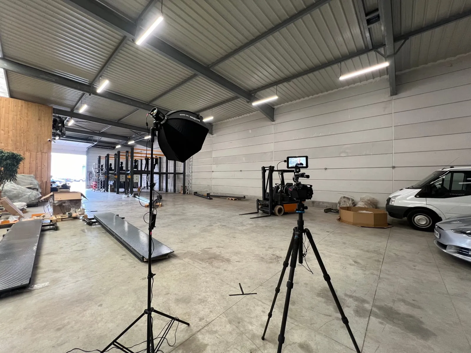 Installation d’une interview dans un entrepôt : caméra sur trépied et lumière avec boîte à lumière