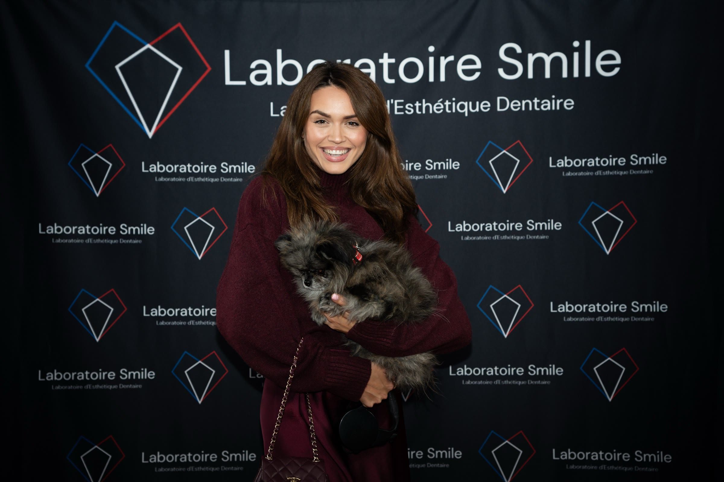 Une invitée et son chien devant le photocall